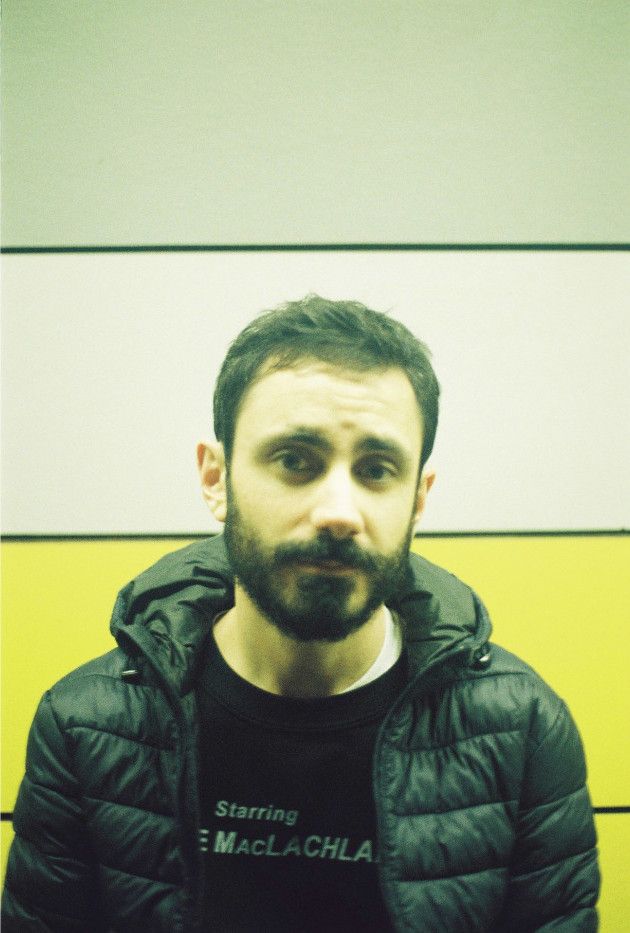 A photo of me looking at the camera in front of a colored striped background